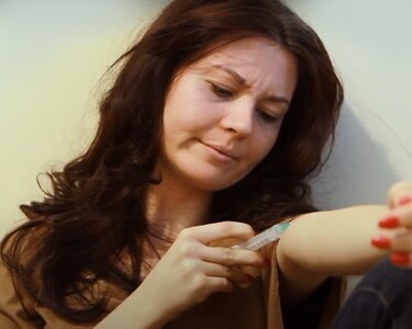 Проблема героиновой зависимости Женщина делает инъекцию себе в руку